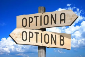 Wooden signposts with text "OPTION A" and "OPTION B" pointing in opposite directions. The signposts are placed outdoors with a clear blue sky and white clouds in the background, symbolizing decision-making or choosing between two options.