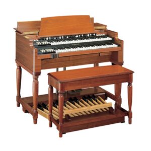 A classic Hammond B3 organ with a wooden cabinet, two manuals (keyboards), drawbars, and a matching wooden bench. Below the organ, a full set of wooden foot pedals is visible, used for bass notes. This iconic instrument, popular in jazz, gospel, and rock music, is known for its rich, warm tones and distinctive rotary speaker sound.